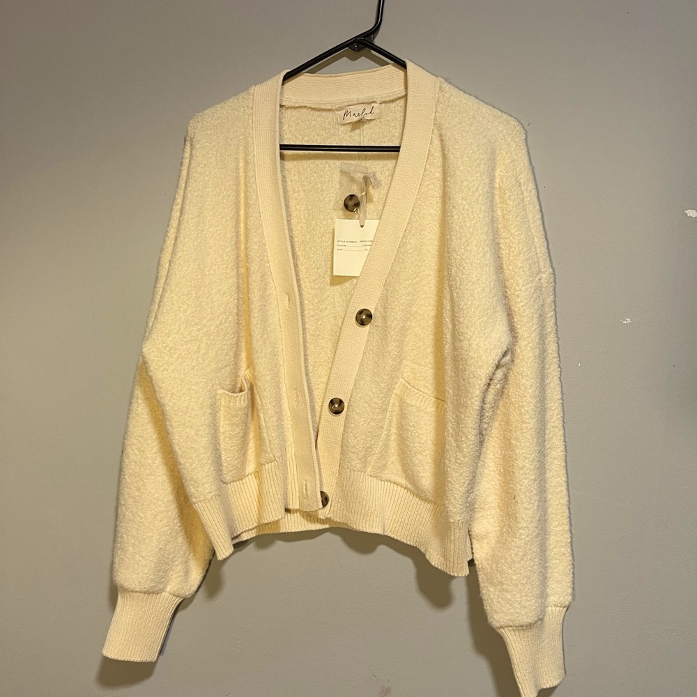 Cute cream colored cardigan with pockets and buttons.